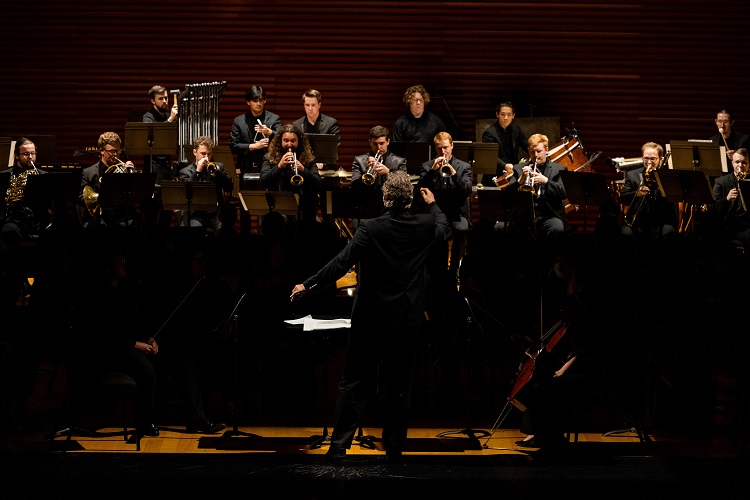 An orchestra performs onstage.