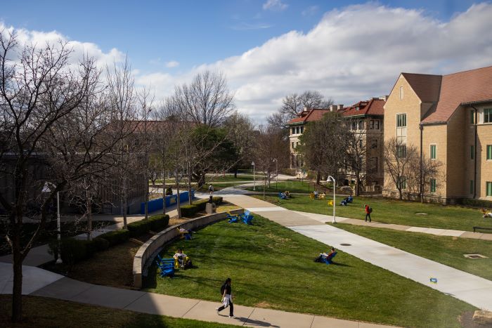 View of the quad with students sitting outside in the spring sunshine