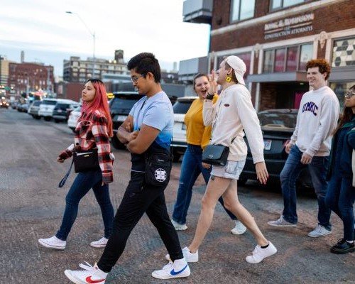 group of students crosses the street in Kansas City crossroads during First Friday gallery walk night