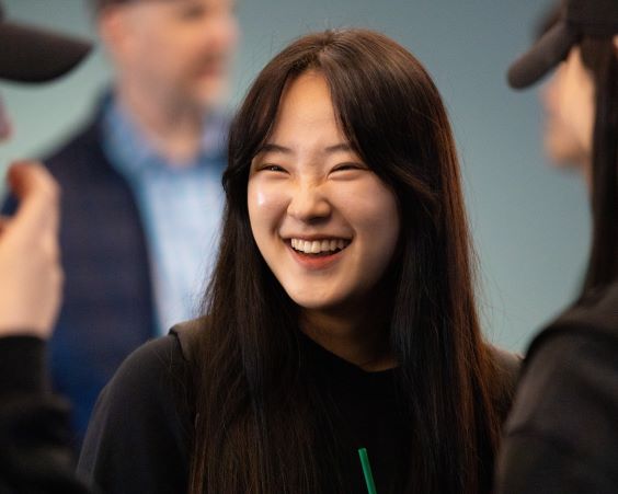 Student smiles while enjoying a drink at a celebration of Korean culture
