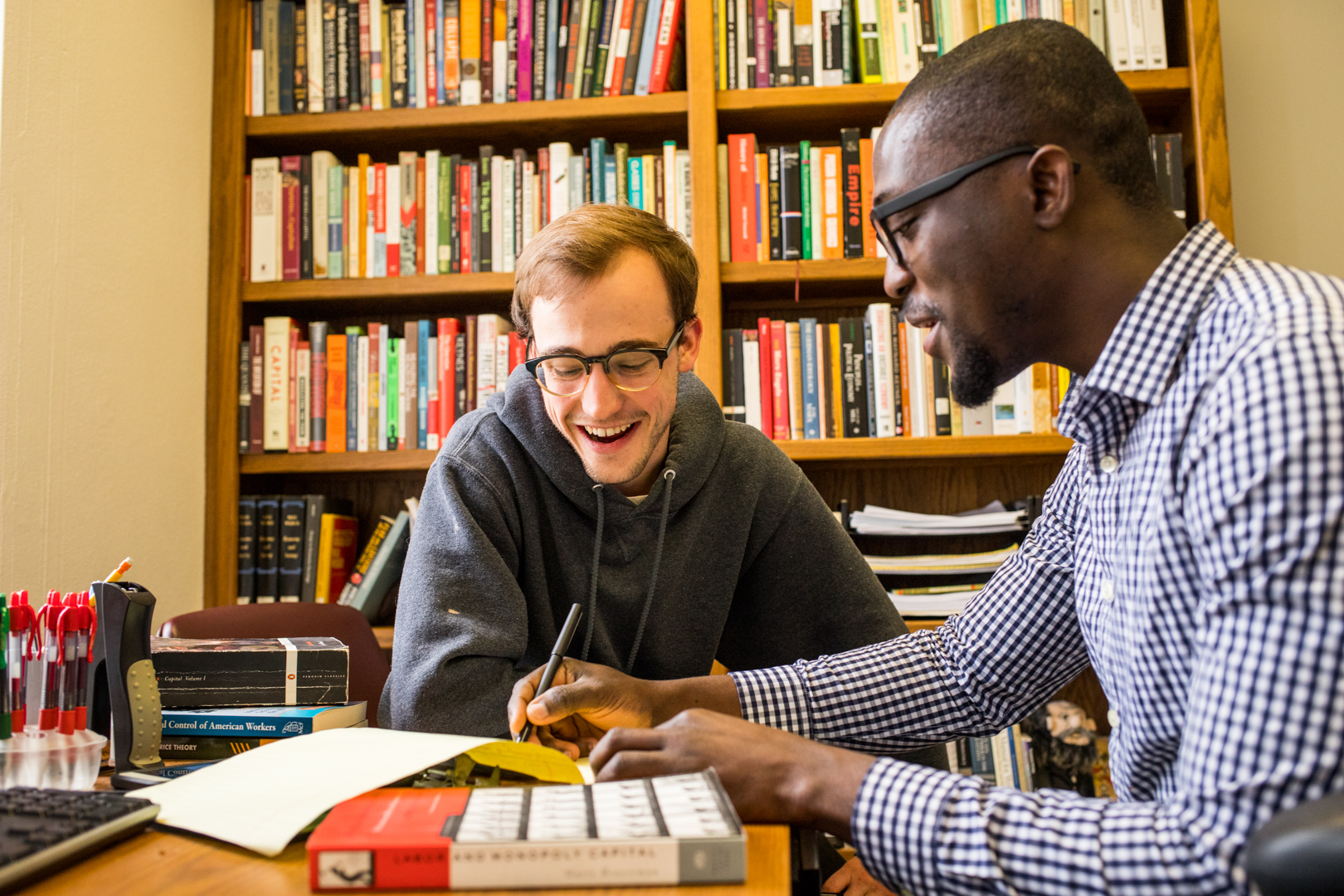 two men working together on a document