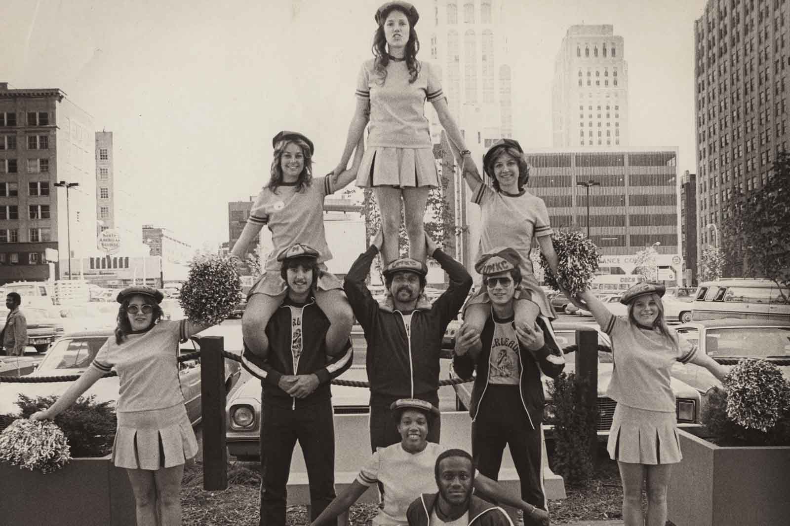 UMKC cheerleaders in black and white picture stand in a pyramid