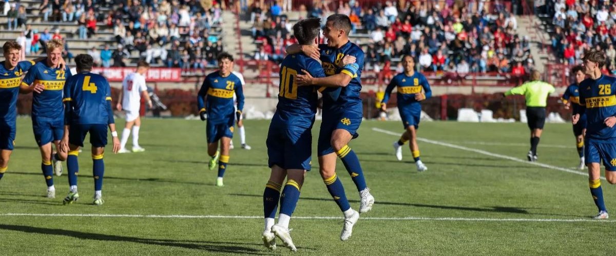 Two UMKC players bring the ball down the field with an opponent nearby