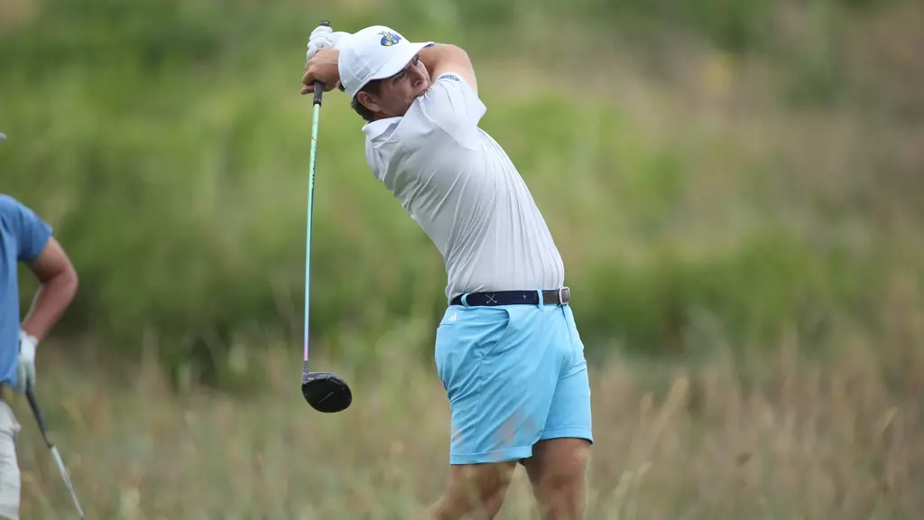 Member of the golf team takes a swing on course