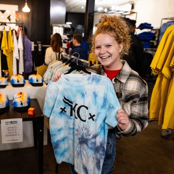 A UMKC student shows off a tie-dye UMKC Roos Mobb t-shirt at Made Mobb at the 2023 Crossroads Arts District pop-up event.