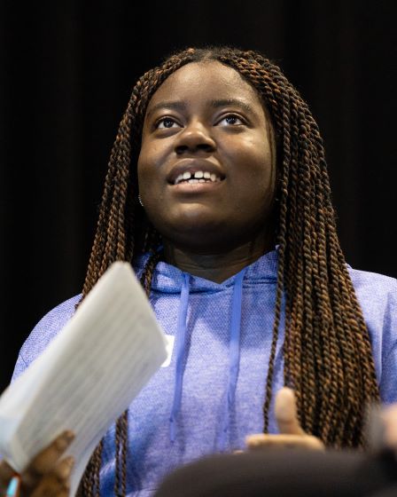 A student standing and holding some print outs at a Professional Career Escalators event at UMKC looks inspired and focused.