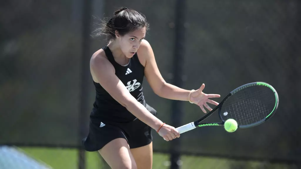 KC Roos women's tennis player hits a backhand on court