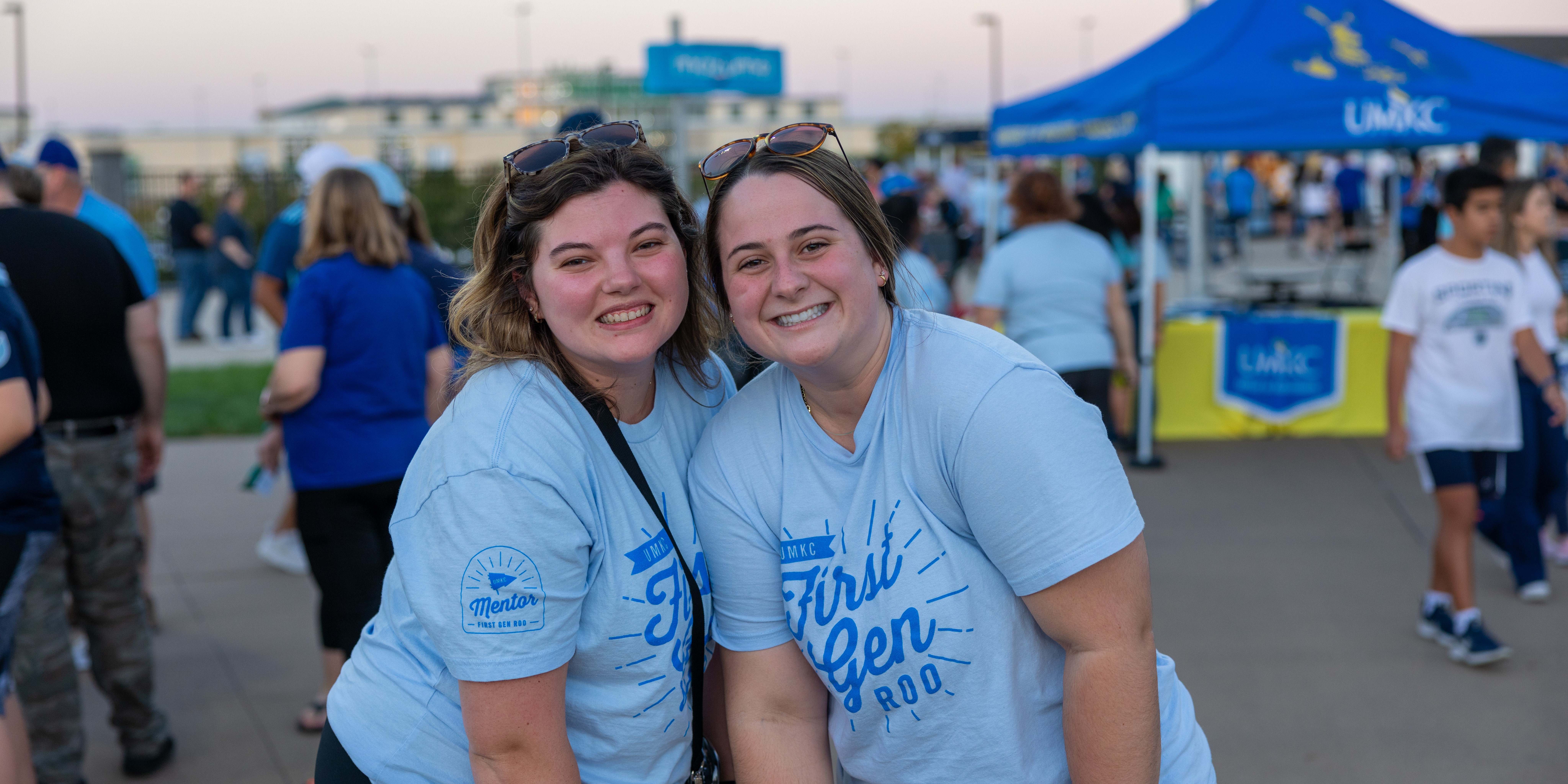 Two students dressed in light blue shirts pose outside the Sporting KC field for UMKC Night at Sporting KC