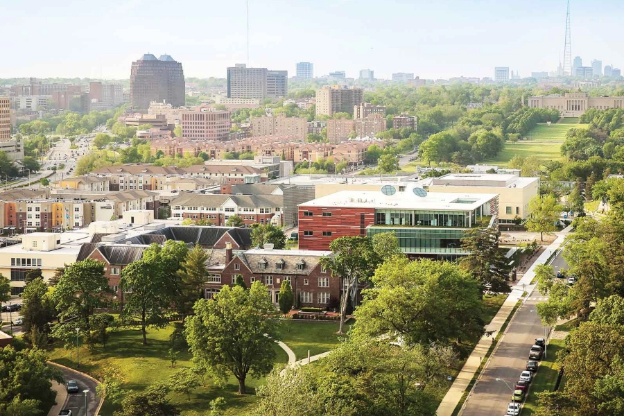 An aerial view of UMKC's Volker Campus, featuring the Henry Bloch School of Business, Student Union, residence halls, and Kansas City's Nelson Atkins museum in the background.