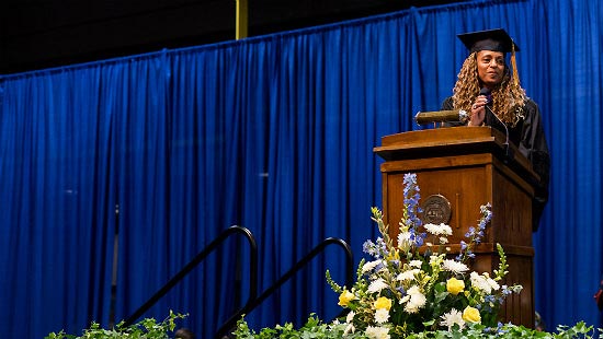 Attorney Michelle Wimes (B.A. ’88), on stage delivering the College of Arts and Sciences commencement address.