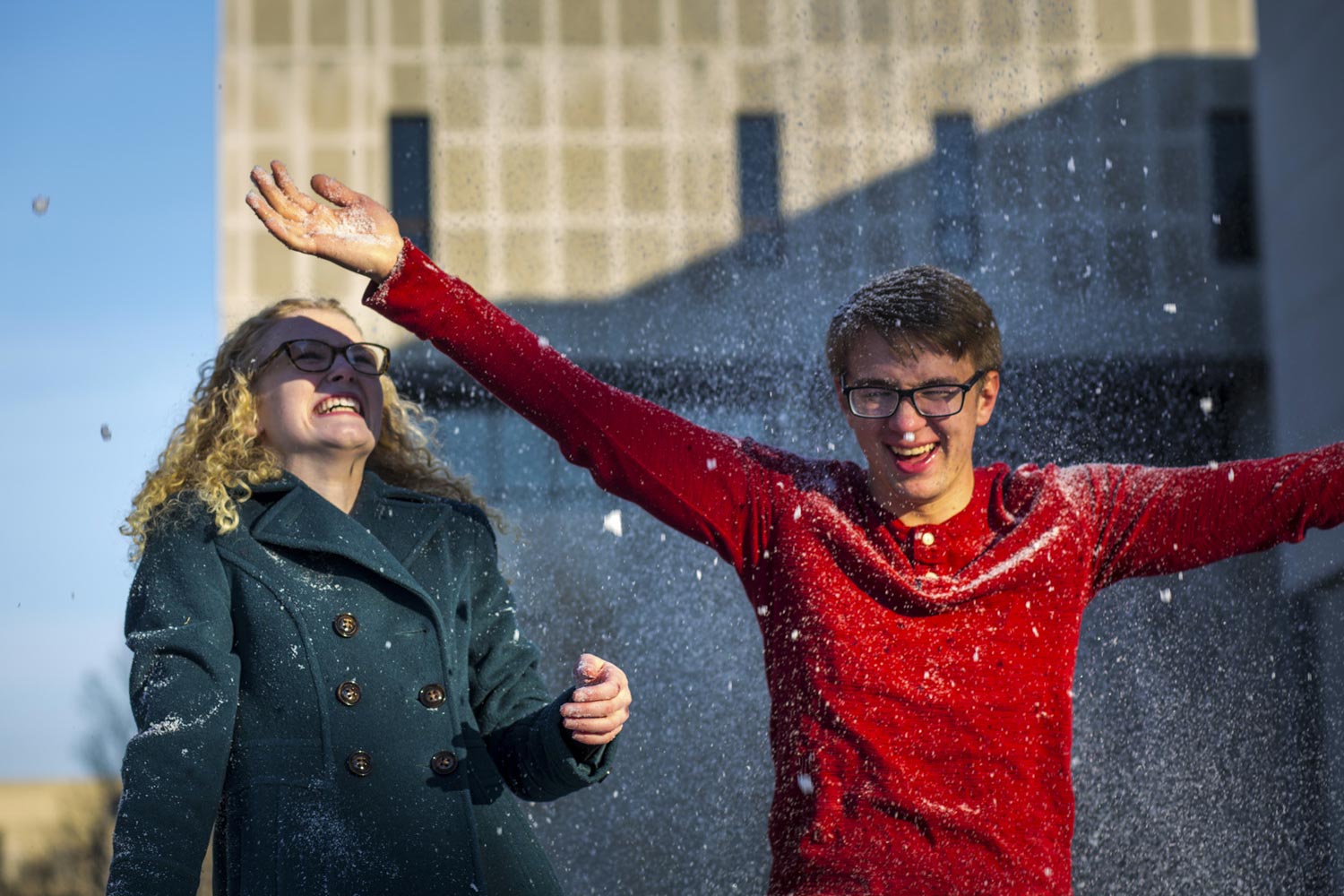two students laughing as the snow falls