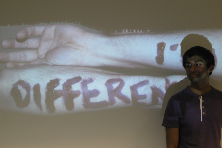 A UMKC School of Medicine student stands in front of a screen that says "different."