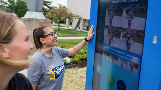 students using the touch-screen kiosks on campus
