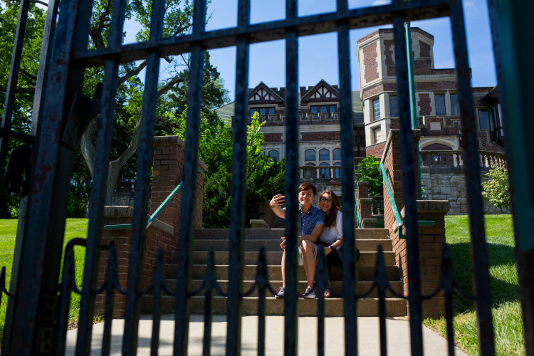 Students stand near Epperson House gate.