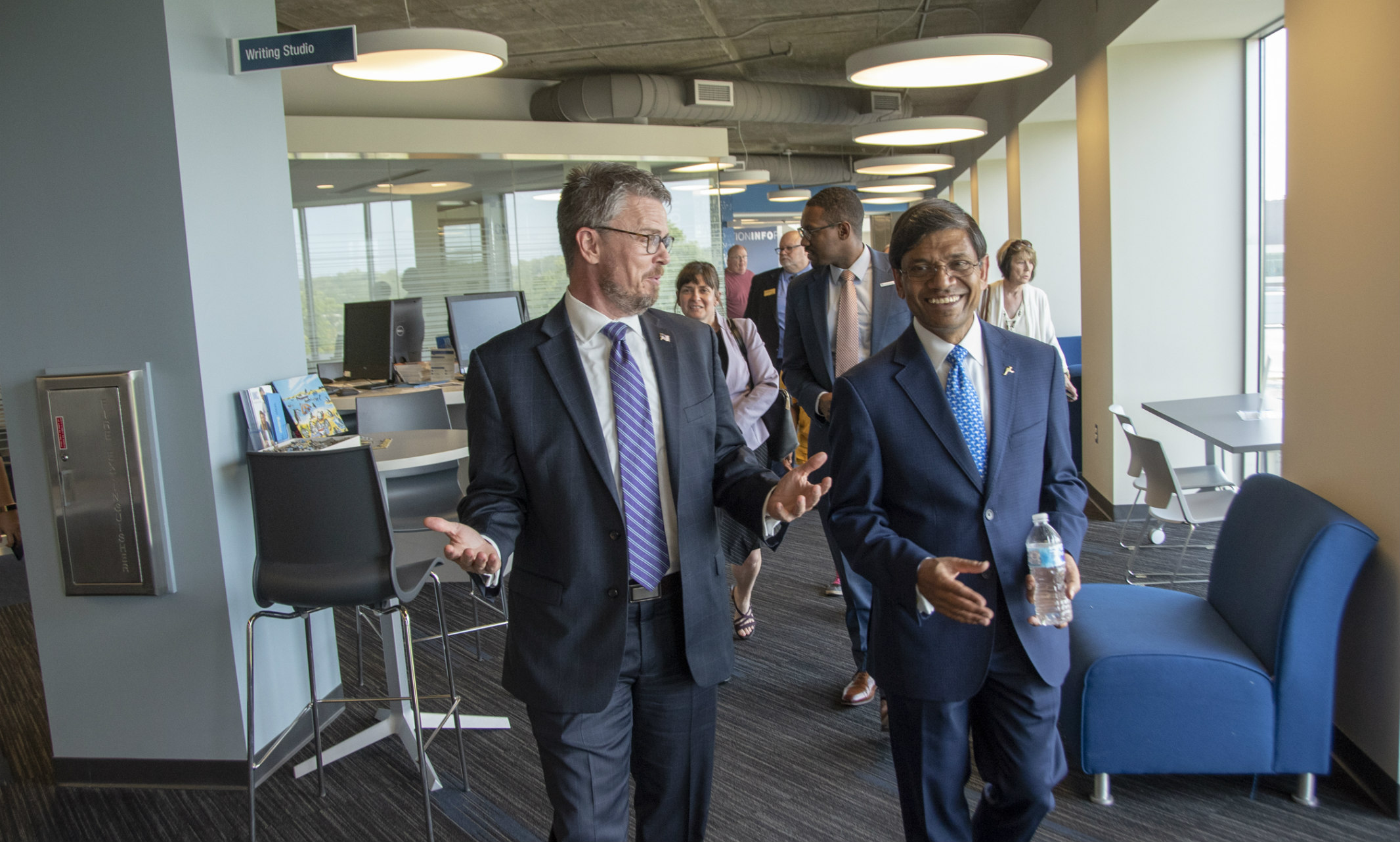 Johnny Collett, assistant secretary of education, walks down a hallway with UMKC Chancellor Mauli Agrawal.