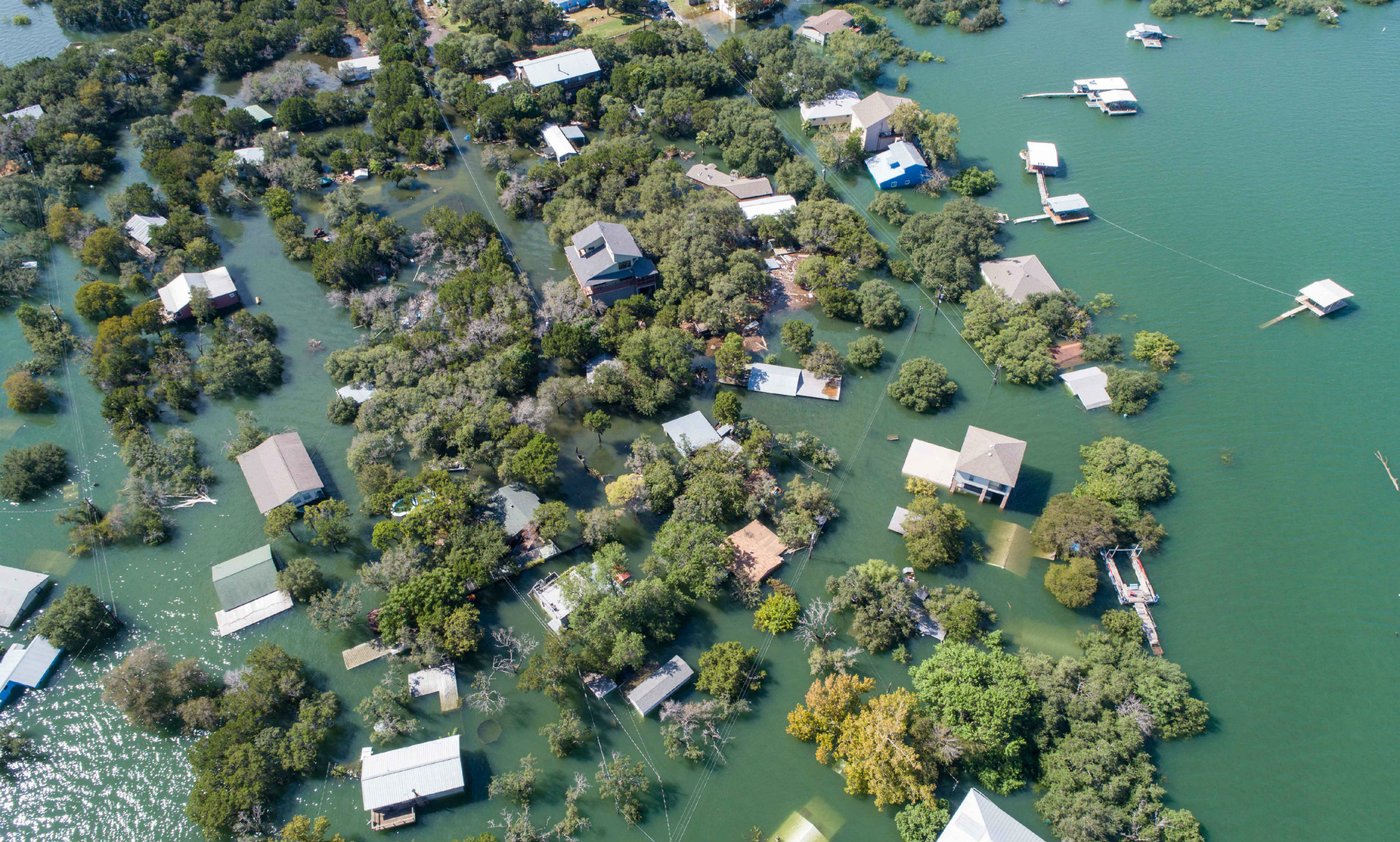 Aerial image of a flooded neighborhood with lots of houses and trees 