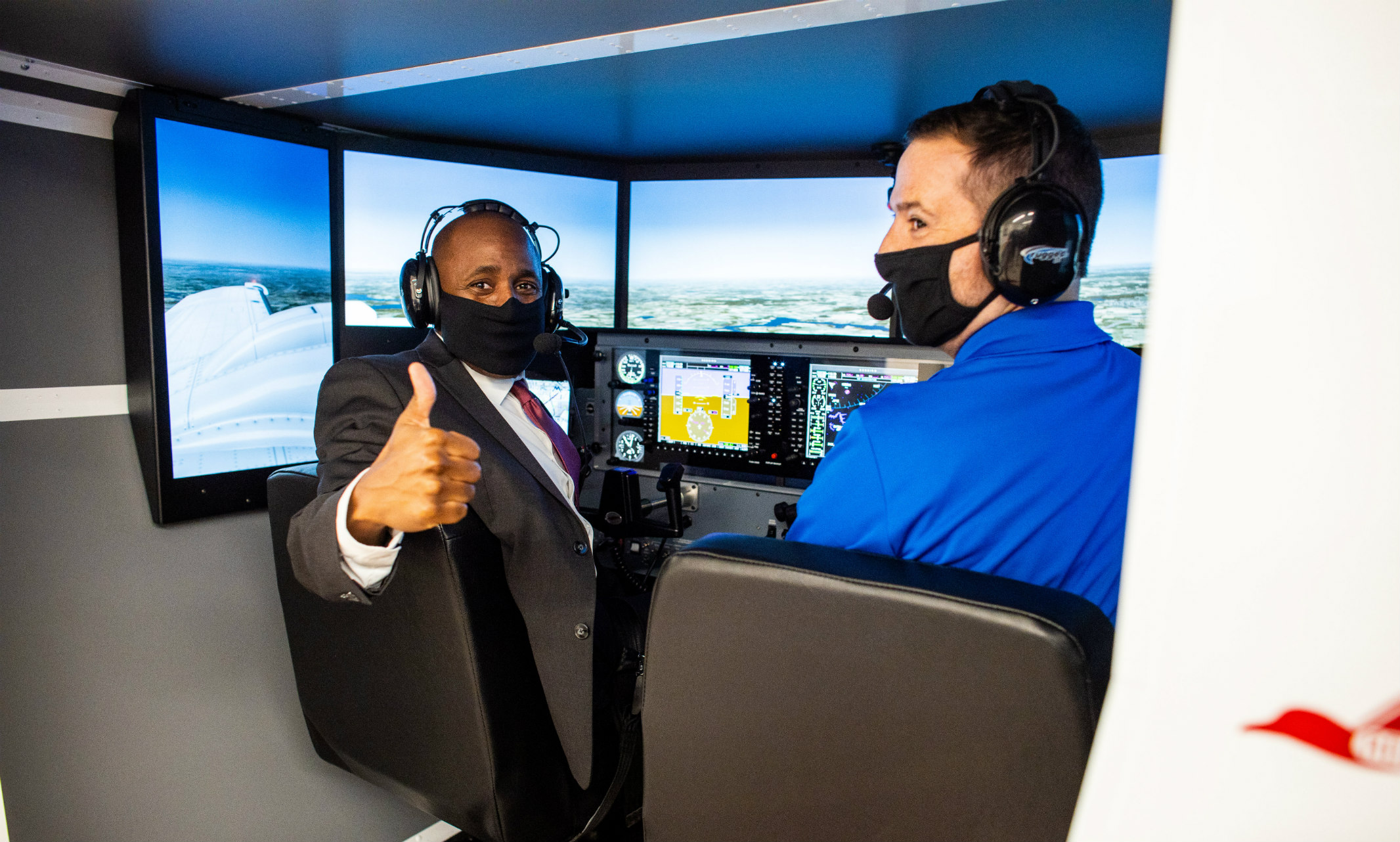 Mayor Lucas gives thumbs up while preparing to test the flight simulator at the School of Computing and Engineering