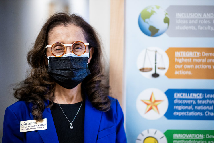 Sally Ellis Fletcher wearing a mask and standing near health sciences display