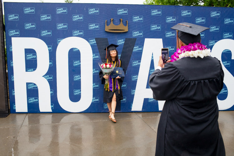 Female grad in front of Royals sign