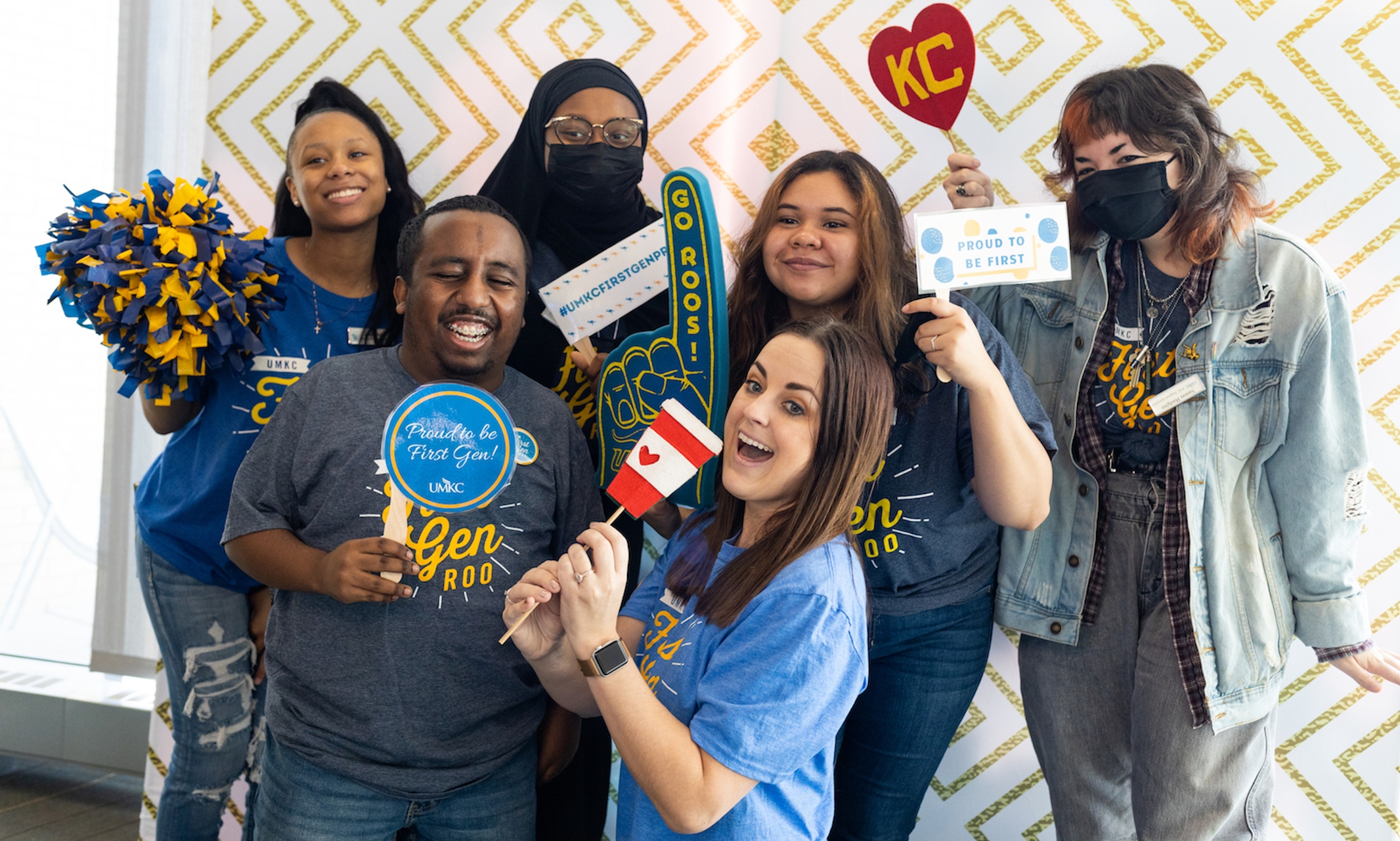 Students and mentors pose together with props in the photobooth at Student Union.