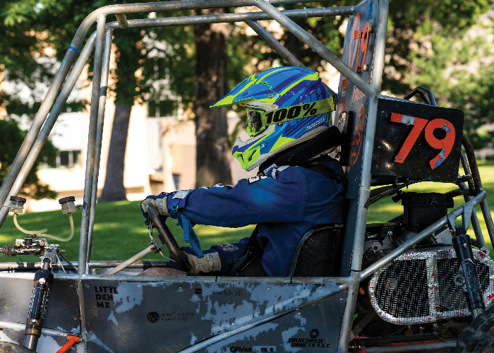 student with helmet in racing buggy