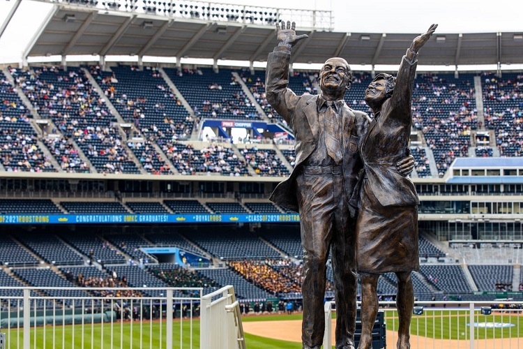 A statue of the Kauffmans with the field and stadium seats in the background