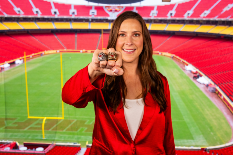 Meghan Jaben poses with two super bowl rings on her hand.