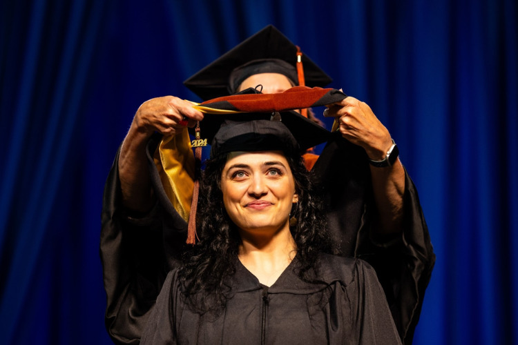 Graduate student receives their stole at graduation. 