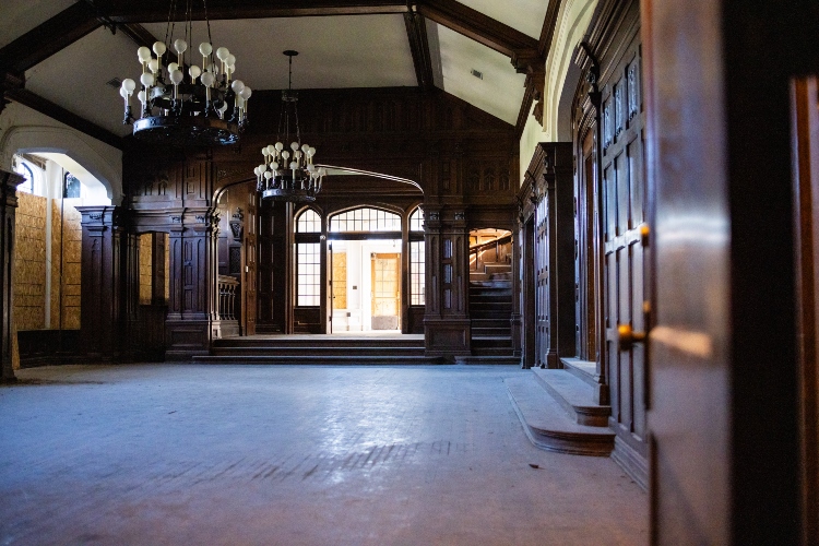 A tudor style ballroom with dark wood. The room is empty and dusty