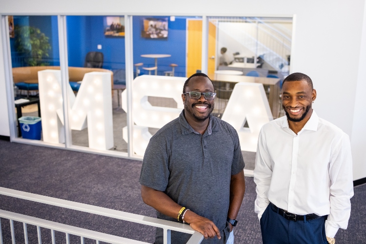 Roland Hemmings and Aijalon Edwards stand together smiling with big, light up letters behind them that say, "MSA"