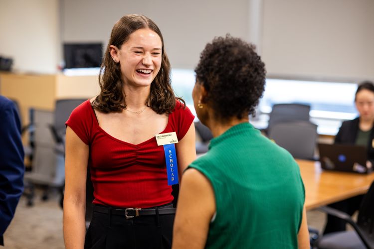 umkc trustees' scholar in red laughing as they chat with Trustee Debby Ballard