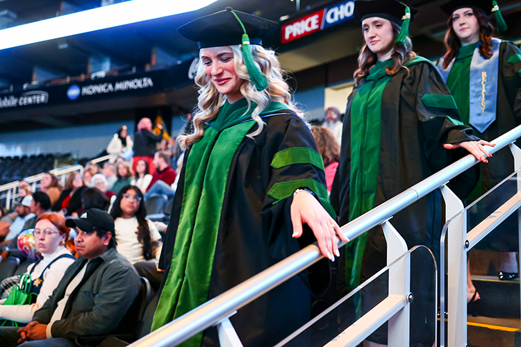 Female graduates walking down stairs.