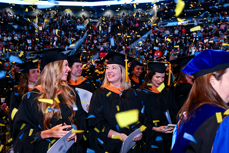 Graduates celebrating in confetti