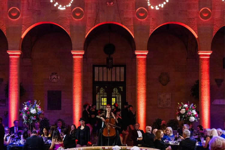 Student musicians play in the entrance to Rozzelle Court, audience members are seated around them