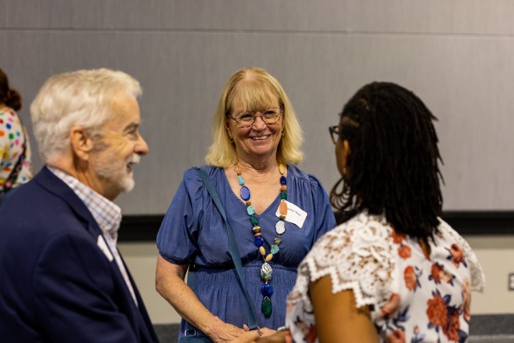 Dana and Nancy chatting with a student at an IUE event