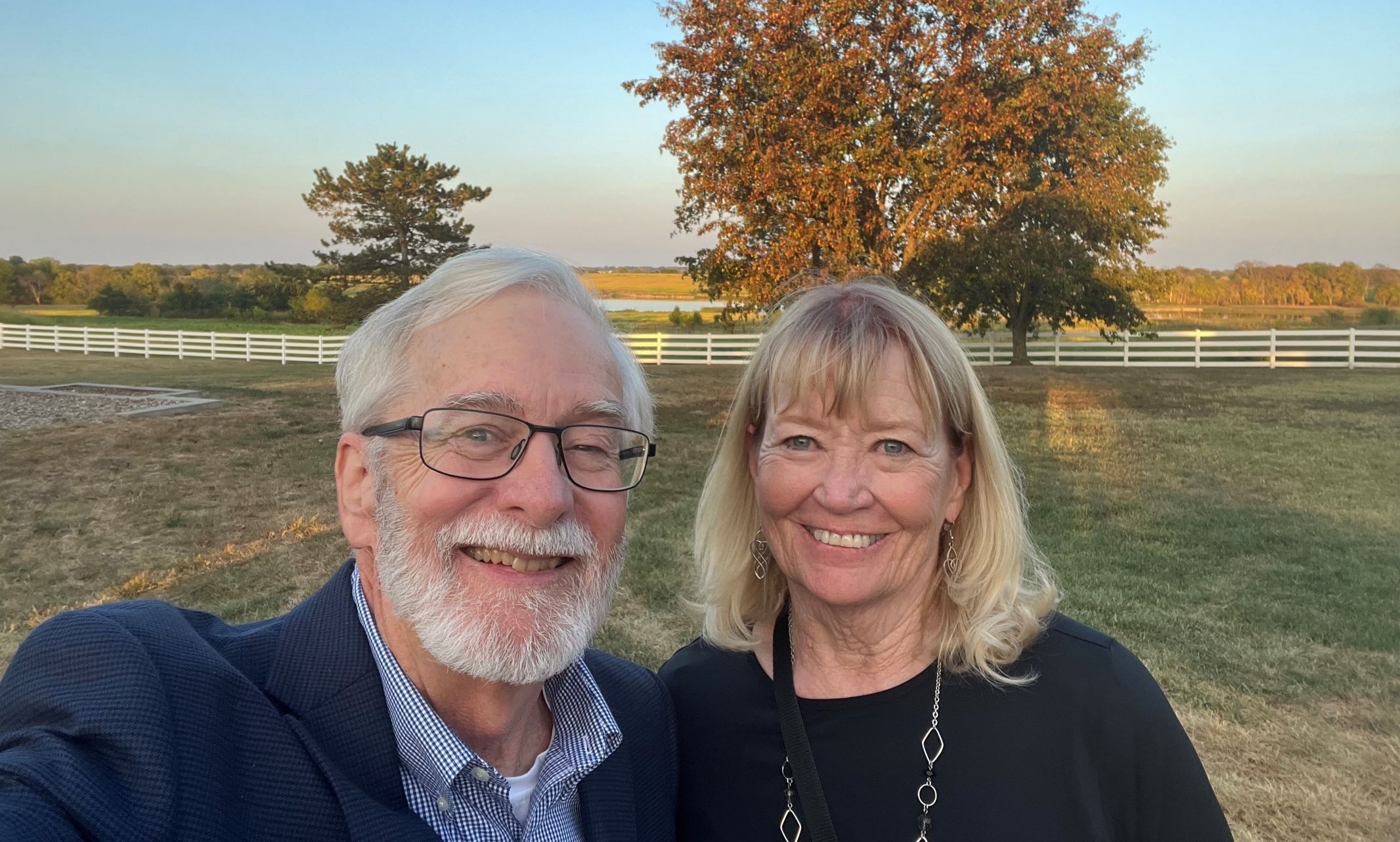 UMKC donors Dana and Nancy Reel taking a selfie in front of a tree at sunset