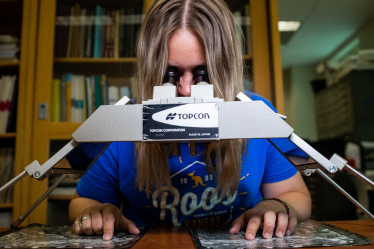 Student looks through a microscope.