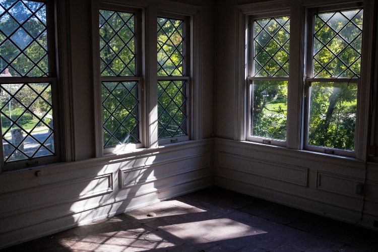 A sewing room with large windows and white woodwork, on an upper floor of Epperson House