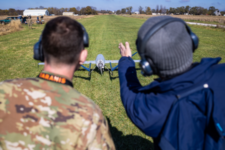 Two people discuss about the drone on the field.