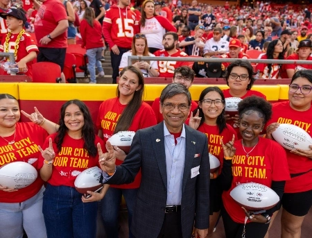 UMKC's chancellor and scholarship recipients pose for a candid photo at on the field at Arrowhead stadium.