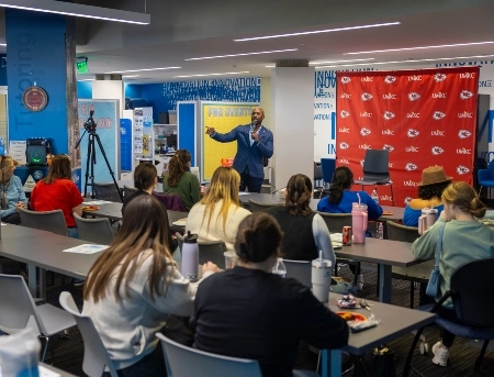 UMKC students listen as someone from the Chiefs organization shares information during a lunch and learn event.