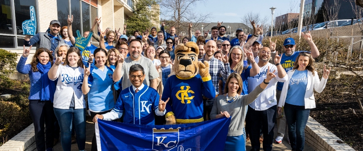 UMKC staff wear Kansas City royals gear and give Roo Up hand signals