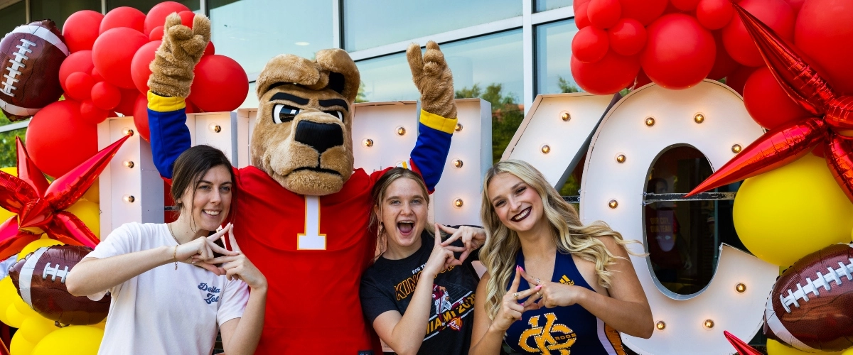 UMKC students and a UMKC cheerleader posing with UMKC's Roo mascot during the Chiefs partnership launch celebration.