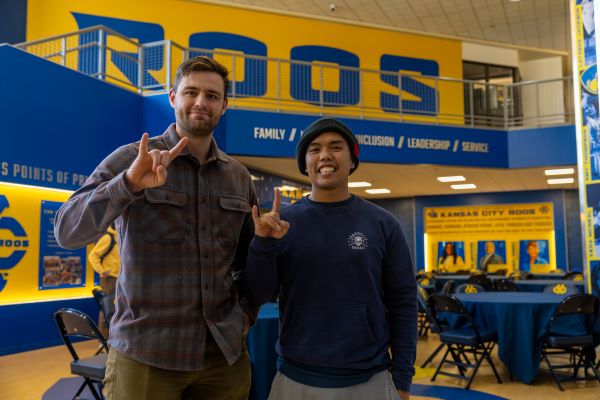 Two students make the Roo Up hand signal during the veterans day lunch.