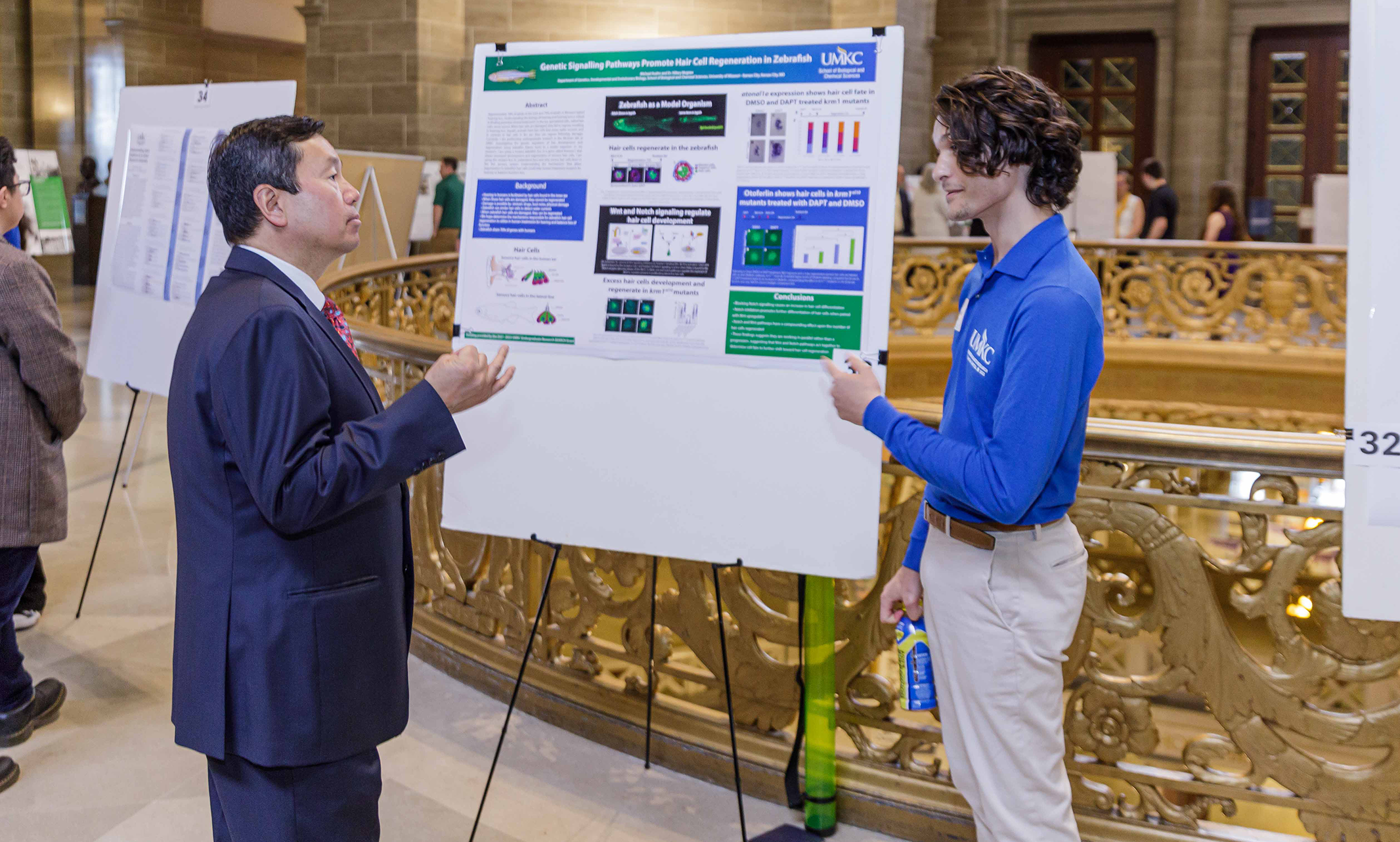 A student presents a research poster to UM System President Mun Choi