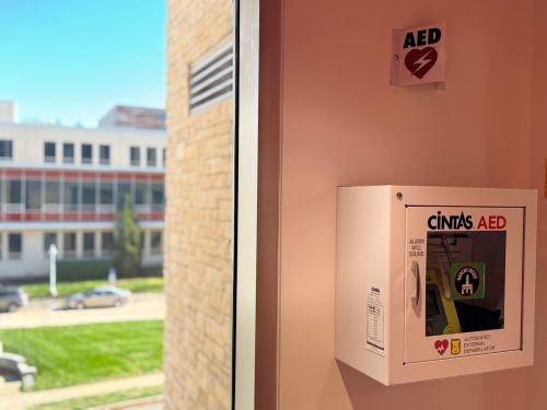 Image of AED box with Narcan Sticker on Front Window.